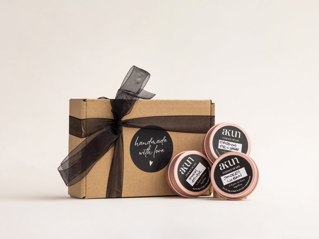 AKUN Essence of Life candle set featuring three distinct fragrances presented in rose-toned tins with handcrafted gift packaging