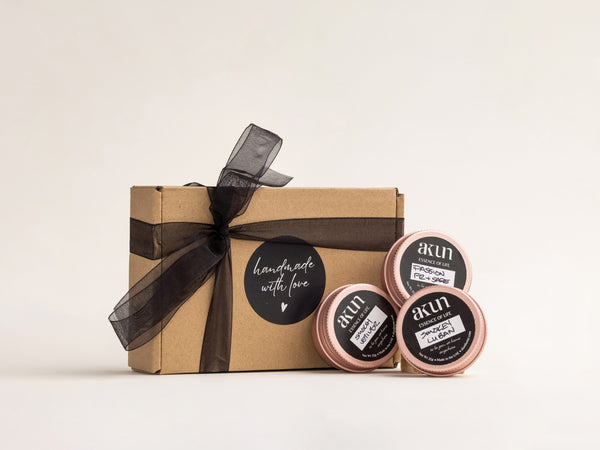 AKUN Essence of Life candle set featuring three distinct fragrances presented in rose-toned tins with handcrafted gift packaging
