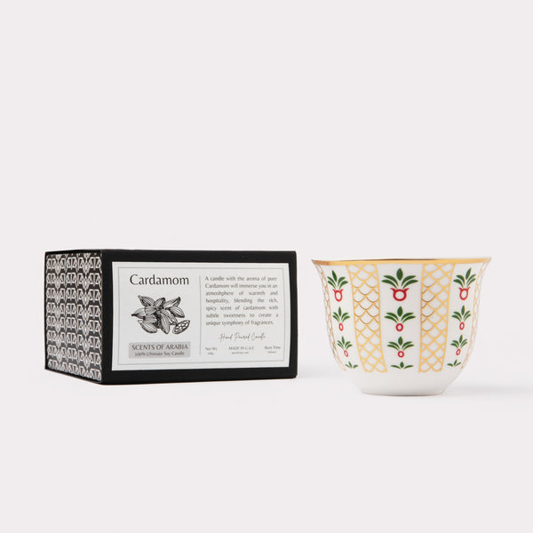 AKUN Scents of Arabia cardamom fragrance candle paired with a gold-trimmed ceramic cup in a clean studio setting